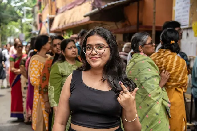 জীবনে প্রথমবার ভোট দেওয়ার পর সগর্বে আঙুলে লাগানো কালি দেখাচ্ছেন একজন তরুণী