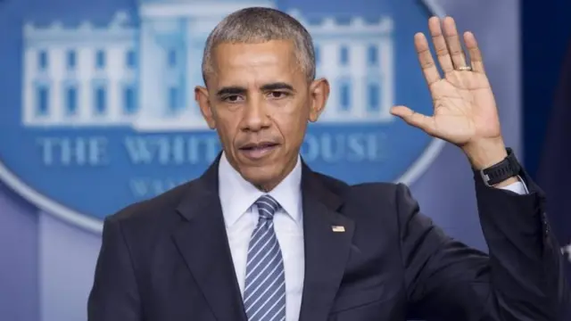 Obama levanta su mano izquierda.