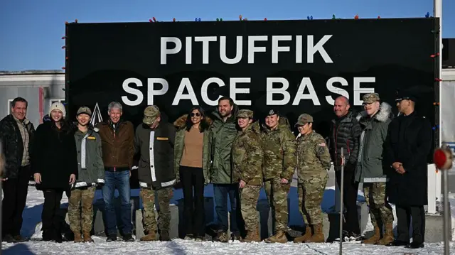 Групповое фото с четой Вэнс на фоне надписи «Космическая база Питуффик».