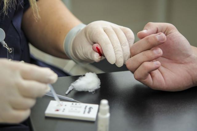 Enfermeira coleta uma amostra de sangue para um teste de dengue em um posto de saúde 