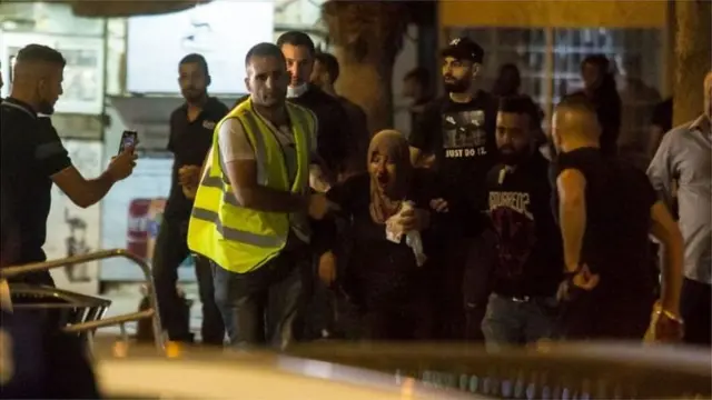 সহিংসতায় আহত একজন নারীকে নিয়ে যাওয়া হচ্ছে