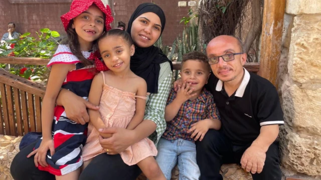 هيثم السقا يجلس مع أسرته على أنقاض منازل مهدمة في قطاع غزة