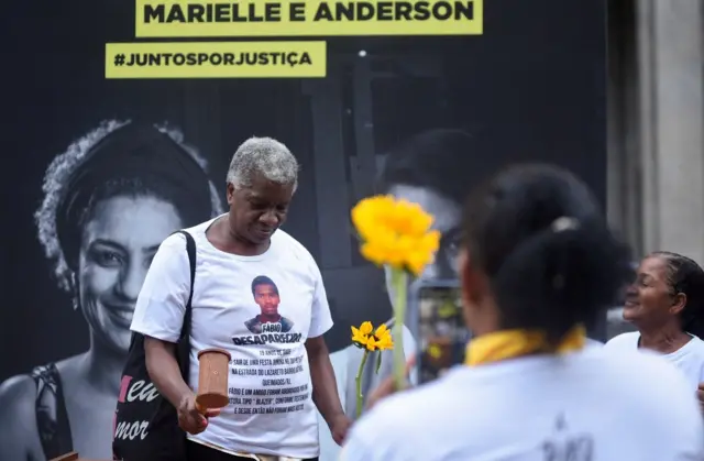 Mulher com martelo, representando a Justiça,baixar casas das apostasfrente a cartaz com fotobaixar casas das apostasMarielle e texto 'Marielle e Anderson; #JuntosporJustiça'