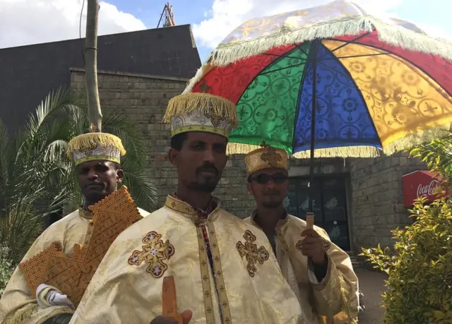 Священики позують для фото з парасольками