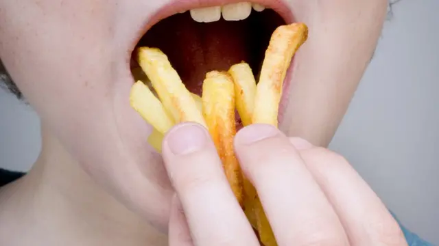 Pessoa comendo batata frita