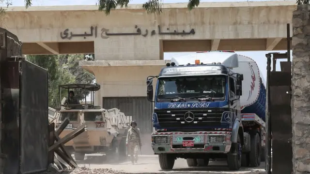 Egyptian security forces stand guard as lorries carrying fuel enter the southern Gaza Strip from Egypt through the Rafah border crossing on 21 June 2017