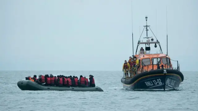 قارب نجاة يساعد عدد من الأشخاص الذين حاولوا عبور القنال الإنجليزي في قارب صغير في نوفمبر 2021