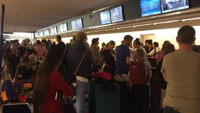 Pasajeros del vuelo 2036 de British Airways hacen cola para abordar por tercera vez.