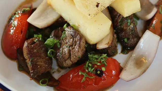 Plato peruano lomo saltado. Contiene carne, cebolla, tomate y papas.