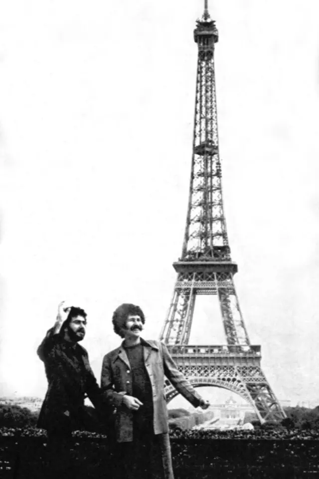 A dupla em frente à Torre Eiffel, em foto em preto e branco