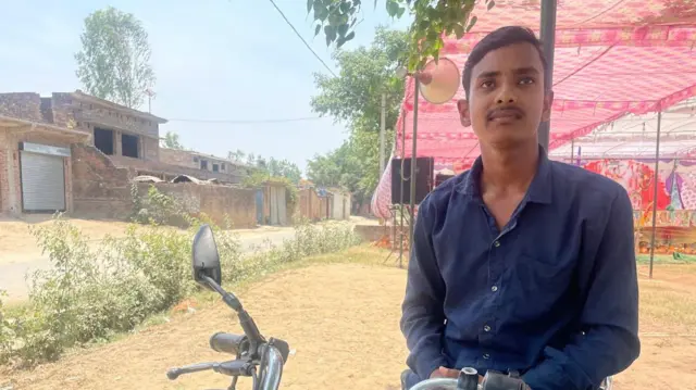 मोटरसाइकिल पर खड़ा युवक