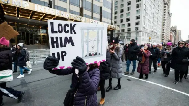 مردمی که پلاکاردی برای زندان انداختن ترامپ در دست دارند