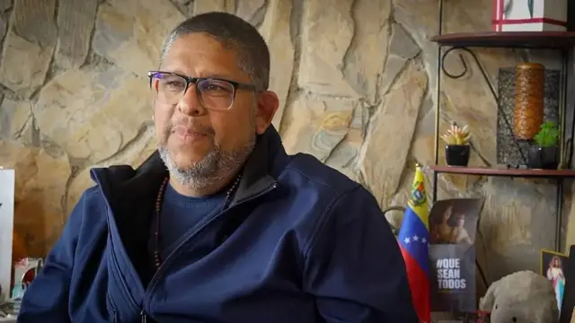 Ángel Godoy reflexiona y mira a la distancia durante su conversación con la BBC. Viste una camiseta y chaqueta azul