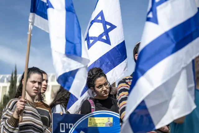 تعدادی از معترضان با پرچمهای اسرائیل