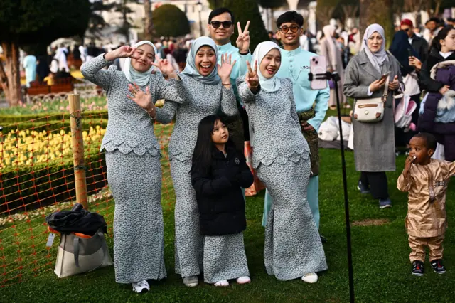 عائلة تتحدث مع أصدقائها عبر الهاتف خلال صلاة عيد الفطر، بمناسبة نهاية شهر رمضان، خارج مسجد آيا صوفيا الكبير في إسطنبول، تركيا