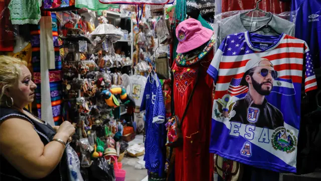 Loja com uma camisasite de apostas betbooBukele junto à bandeira dos EUA e El Salvador