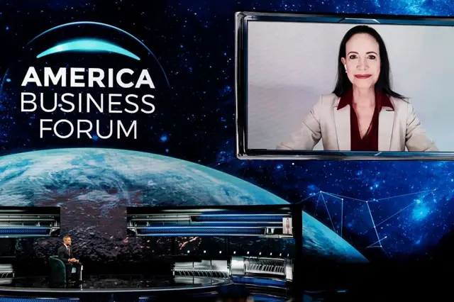 María Corina Machado hablando en un evento empresarial en Miami.