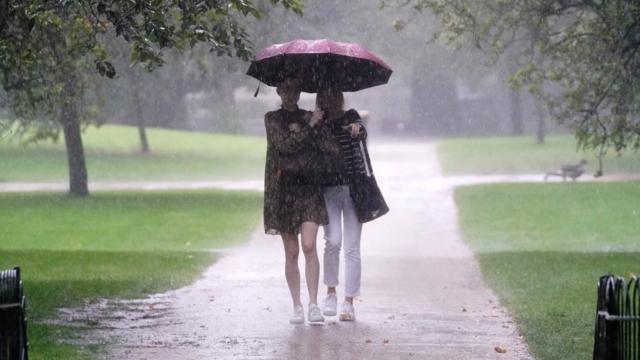 Two women walking in rain