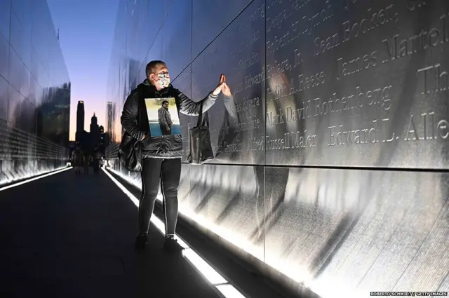 अमेरिका के न्यू जर्सी में 9/11 की याद में बने एक मेमोरियल पर अपने भाई जर्मन के खोदे गए नाम को छूते क्लाउडिया कास्टानो. इस चरमपंथी हमले की 20वीं बरसी पर जारी एक वीडियो में अमेरिका के राष्ट्रपति बाइडन ने उसमें जान गंवाने वाले सभी 2,977 लोगों को श्रद्धांजलि दी.