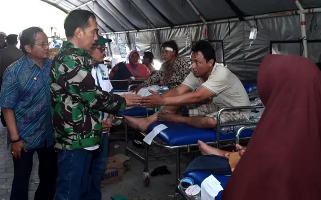 Presiden Joko Widodo didampingi Gubernur Sulawesi Tengah Longki Djanggola (kiri) mengunjungi korban gempa dan tsunami di Palu, Sulawesi Tengah, Minggu (30/9).