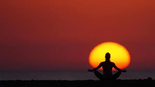 فتاة تمارس التأمل والشمس توشك على المغيب