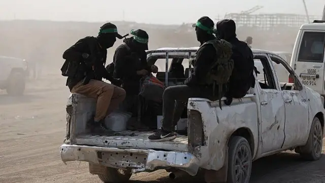  چهار مرد نقاب پوش مربوط به گروه حماس در پشت یک موتر سفید نشسته‌اند