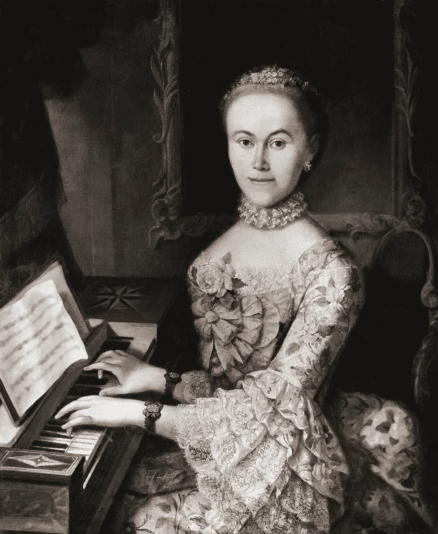 Nannerl, vestida con un traje de encajes, está sentada tocando el piano con las dos manos