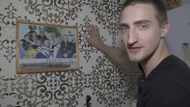Павел показывает фото с родными у себя дома