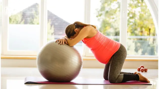 Una mujer embarazada haciendo pilates