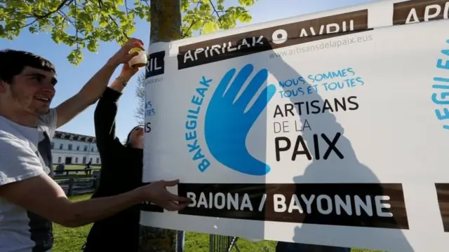Jóvenes preparan pancartas para celebrar la entrega de armas del grupo separatista ETA, en Bayona, Francia