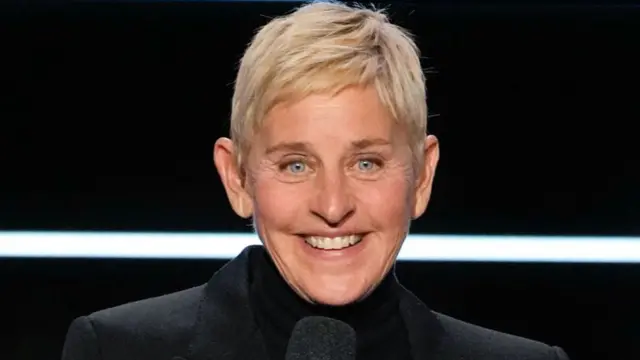 艾倫·德傑尼勒斯(Ellen DeGeneres)身穿黑色外套,並且微笑。