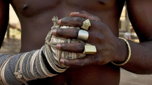 A close up of a dambe fighter's hands, detailing his spear and shield