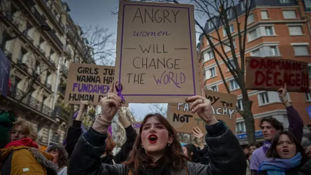 Demonstrantkinje u Francuskoj drže plakate i pevaju dok marširaju kroz centar Pariza da obeleže Međunarodni dan žena 2024.