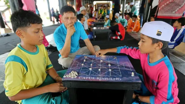 Peserta siswa Sekolah Dasar Negeri mengikuti permainan tradisional, Catur Harimau pada kegiatan Lomba Edukatif Kultural di Museum Aceh, Banda Aceh, Aceh, Sabtu (14/12).