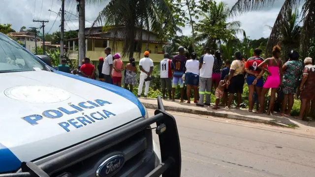 Viaturasportingbet ou betanoperícia, com várias pessoas atrás, observando cena do crime