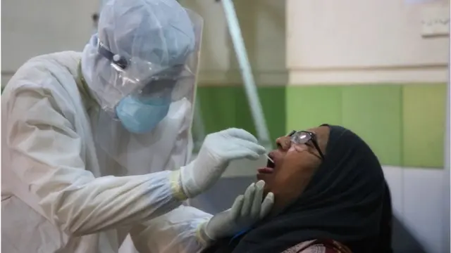 গলা থেকে নমুনা সংগ্রহ করা হচ্ছে।