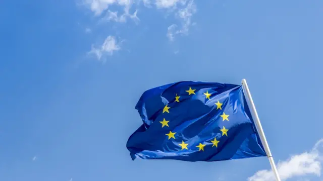 Bandeira da União Europeia com céu azul ao fundo