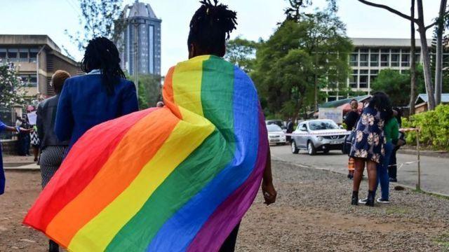 Pesin dey hold gay pride flag