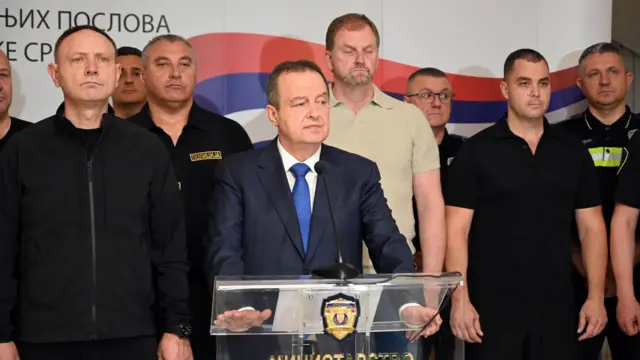 Dragan Vasiljević (levo), Ivica Dačić za govornicom, oko njih nekoliko muškaraca