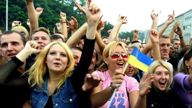 Багато людей кричать і сміються в кольоровому одязі в центрі Києва