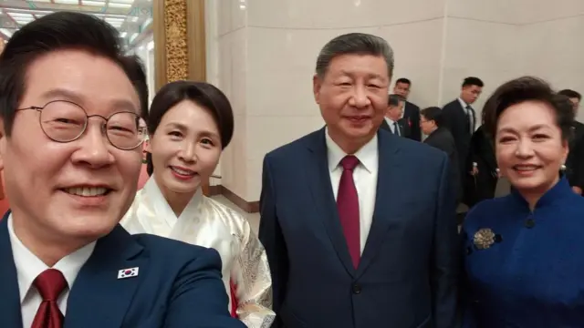 李氏が撮影した自撮り写真に、習氏と両氏の妻がカメラに向かって笑みを浮かべている様子が写っている。李氏と習氏は紺のスーツに赤いネクタイ姿。李氏の妻は白と赤の韓服を、習氏の妻は立襟のついた青いドレスを着ている