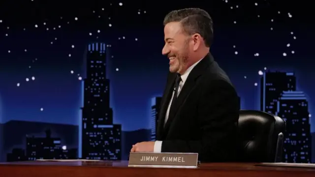 Jimmy Kimmel sonriente y de perfil en el escenario de su programa