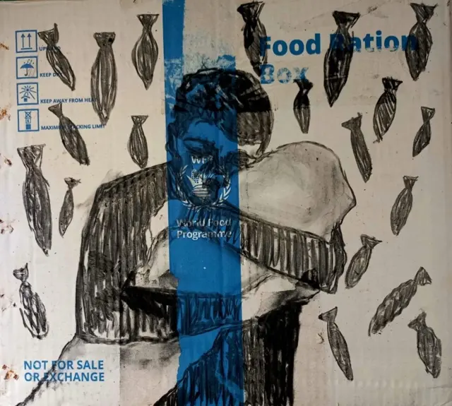 بالأبيض والأسود رسم لأب يحتضن ابنه الرضيع وتتساقط عليهم الصواريخ أيضا على لوحة المساعدات.