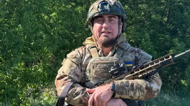 манько стоїть у формі зі зброєю