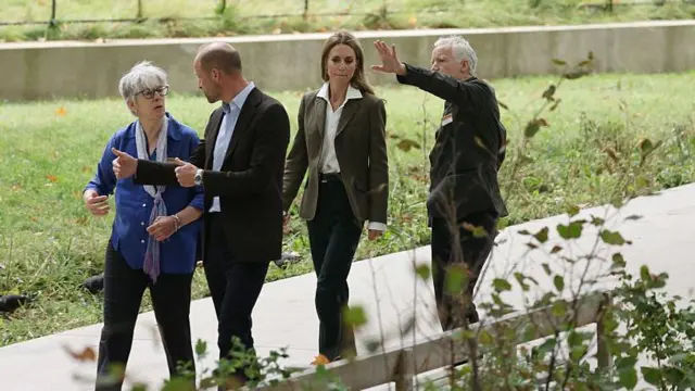 Уильям разговаривает с женщиной из музея, а Кэтрин, идущая немного позади, беседует с директором музея, пока все они прогуливаются по дорожке через сады.