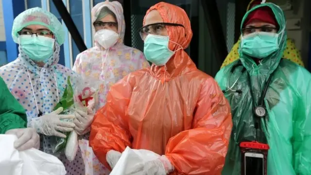 Petugas medis di Banda Aceh mengenakan jas ujan.