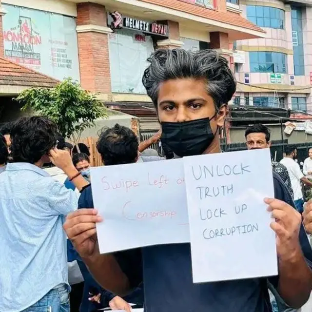 जेन जी आन्दोलनकारी आदित्य कर्ण। भ्रष्टाचारविरोधी प्लाकार्डसहित