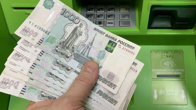 Mano sujetando rublos.