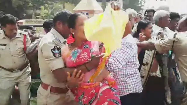 మహిళను నెడుతున్న పోలీసు