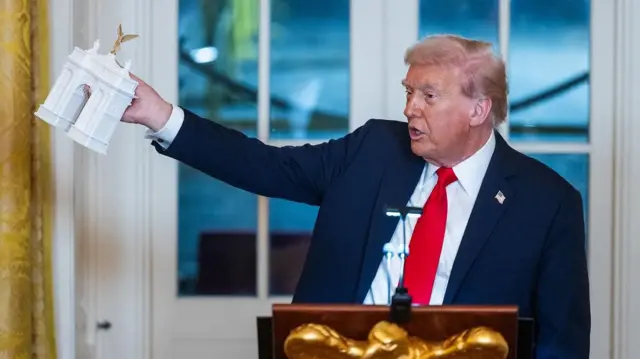 Президент Трамп показує макет арки